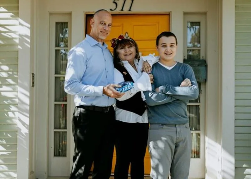 Happy family smiling on the front porch of their home